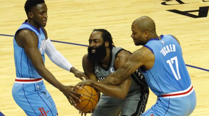 James Harden #13 of the Brooklyn Nets is pressured by P.J. Tucker #17 of the Houston Rockets and Victor Oladipo #7 at Toyota Center on March 03, 2021 in Houston, Texas.
